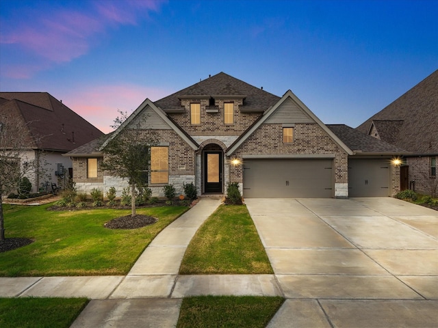 french country home with a garage and a lawn