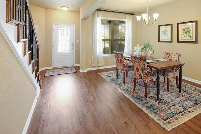 dining space with a notable chandelier and dark hardwood / wood-style flooring