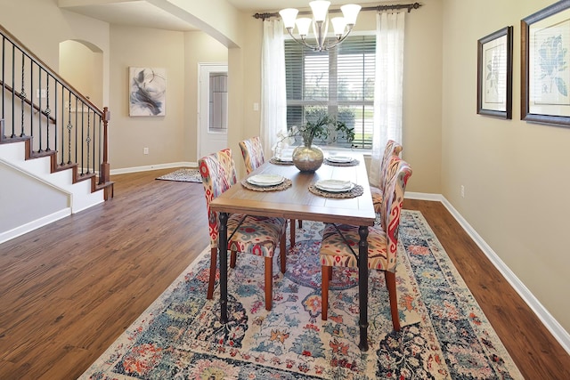 dining area with dark wood-type flooring and a chandelier