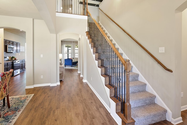 entryway with a high ceiling and wood-type flooring