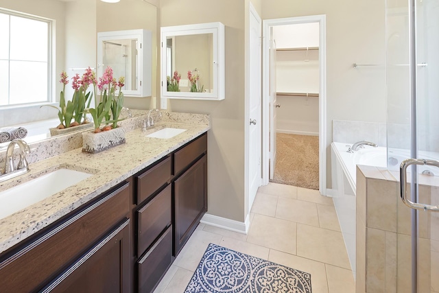 bathroom featuring tile patterned flooring, a bath, and vanity