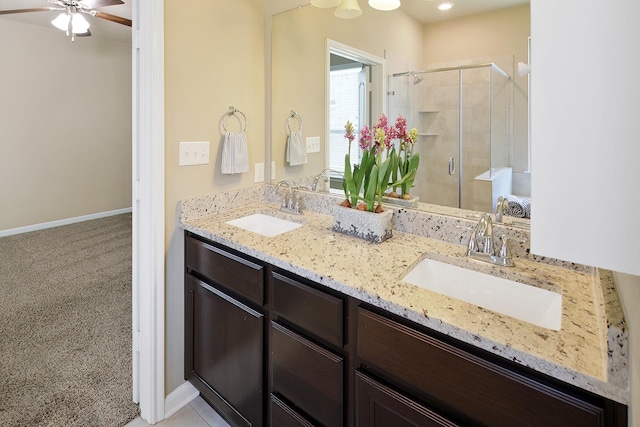 bathroom featuring vanity, a shower with shower door, and ceiling fan