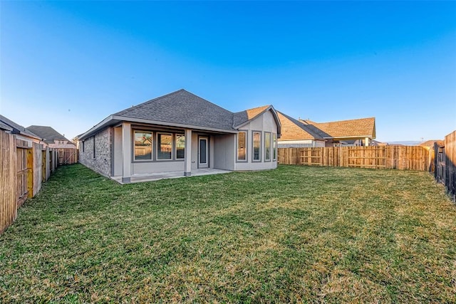 rear view of house featuring a yard and a patio