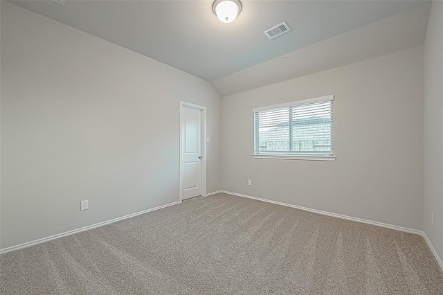 unfurnished room with vaulted ceiling and carpet flooring