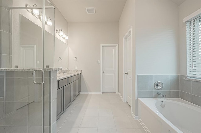 bathroom featuring vanity, a bath, and tile patterned flooring