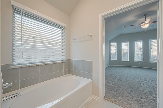 bathroom featuring vaulted ceiling, a washtub, and ceiling fan