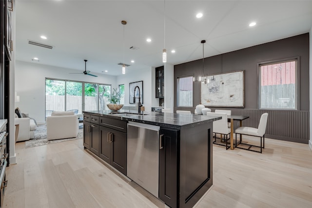 kitchen with visible vents, dark stone counters, a sink, dishwasher, and light wood-type flooring