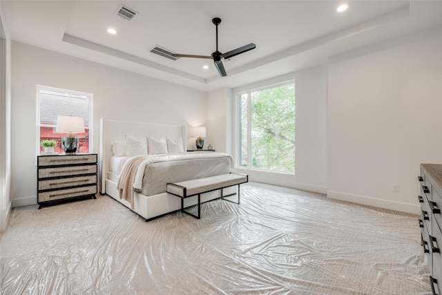 bedroom featuring baseboards, visible vents, recessed lighting, ceiling fan, and a raised ceiling