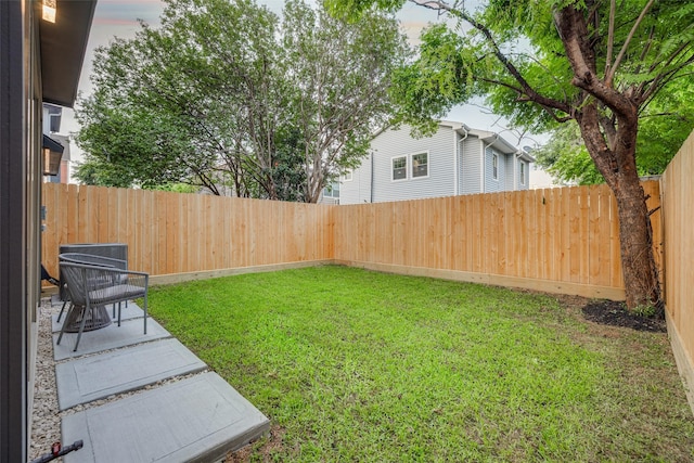 view of yard with a patio, central AC unit, and a fenced backyard