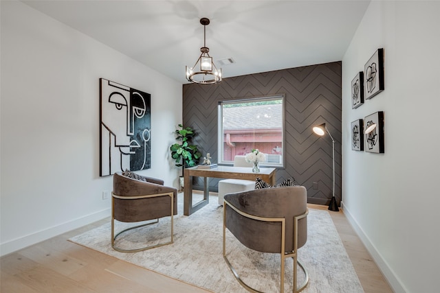 office space featuring visible vents, light wood-style flooring, an accent wall, and baseboards