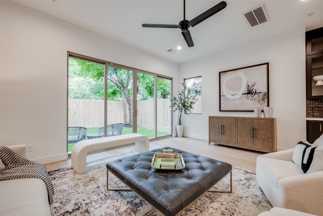 living area featuring visible vents, baseboards, ceiling fan, light wood-type flooring, and recessed lighting