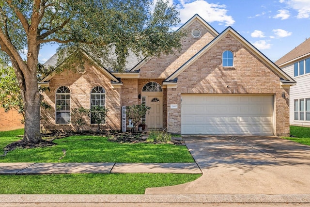 traditional-style house with a garage, a front lawn, concrete driveway, and brick siding