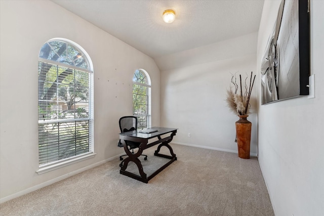 office space featuring carpet floors, baseboards, and vaulted ceiling