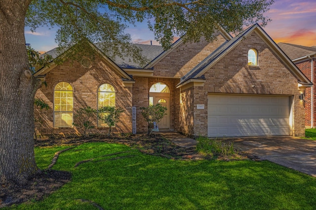 view of front of home featuring concrete driveway, brick siding, a lawn, and an attached garage