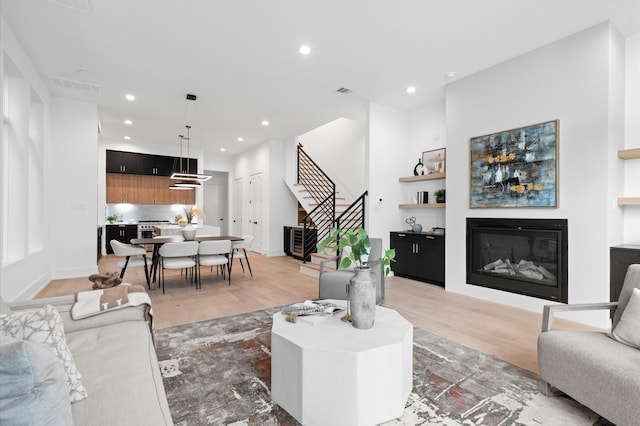 living room with built in shelves and light wood-type flooring