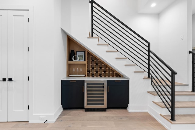 bar featuring wine cooler and light hardwood / wood-style floors