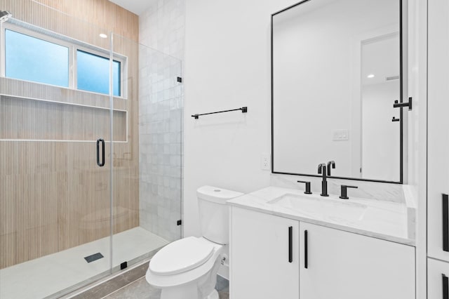 bathroom featuring vanity, toilet, and a shower with shower door