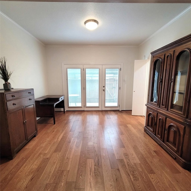 doorway to outside featuring crown molding, light hardwood / wood-style flooring, and french doors