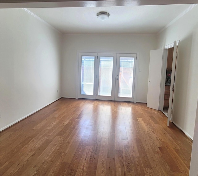 spare room with crown molding, wood finished floors, and french doors