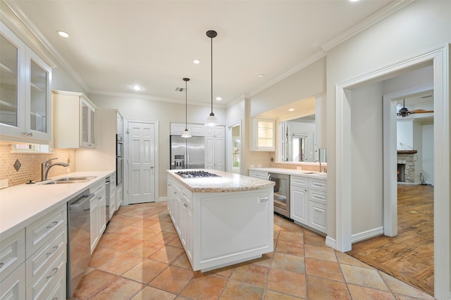 kitchen with sink, a center island, white cabinets, and appliances with stainless steel finishes