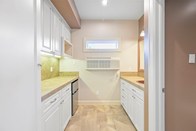 kitchen featuring white cabinetry, decorative backsplash, and refrigerator