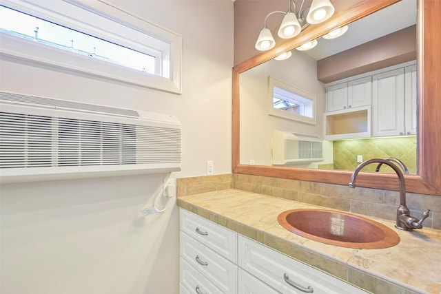 bathroom featuring tasteful backsplash, vanity, and a wall mounted air conditioner