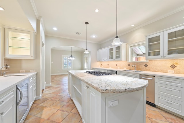 kitchen with a kitchen island, decorative light fixtures, sink, white cabinets, and stainless steel appliances