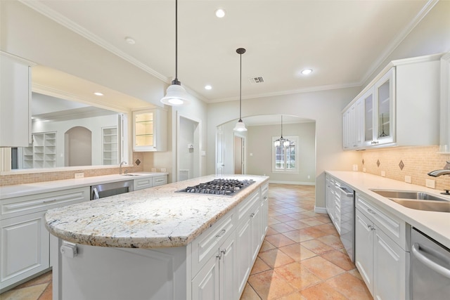 kitchen with sink, stainless steel appliances, white cabinets, a kitchen island, and decorative light fixtures