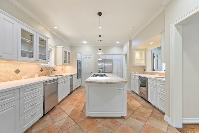 kitchen featuring sink, decorative light fixtures, a center island, appliances with stainless steel finishes, and white cabinets