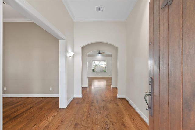 corridor featuring ornamental molding and light wood-type flooring