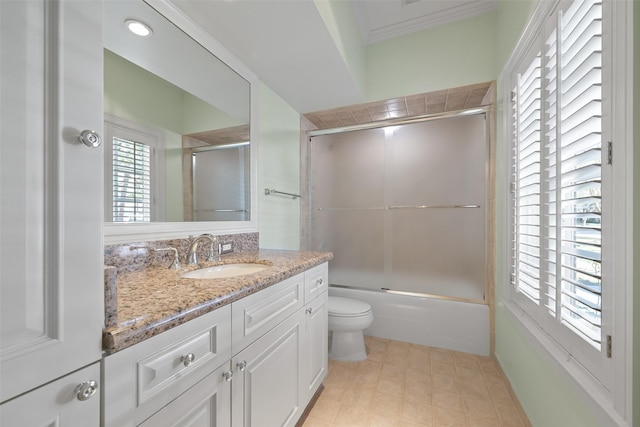 full bathroom with vanity, ornamental molding, enclosed tub / shower combo, and toilet