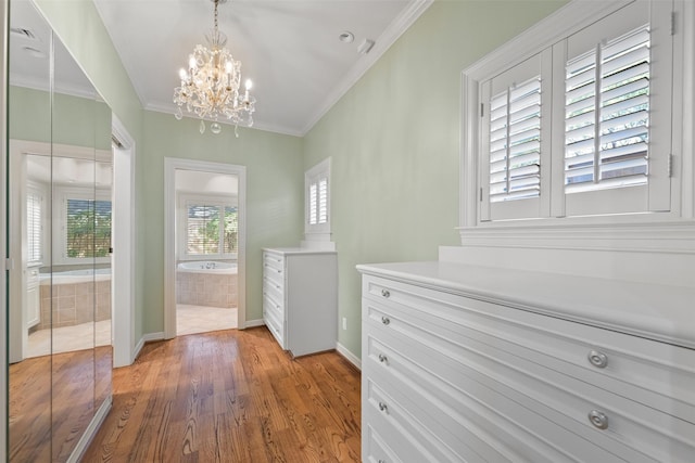 doorway featuring hardwood / wood-style flooring, crown molding, and a notable chandelier