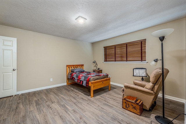 bedroom with wood-type flooring and a textured ceiling