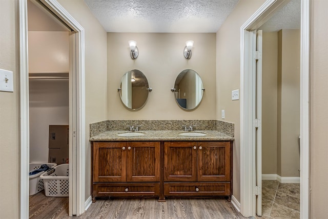 bathroom featuring vanity, hardwood / wood-style flooring, and a textured ceiling