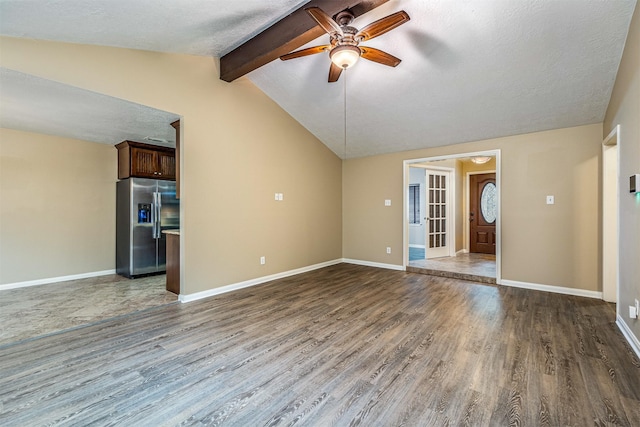 unfurnished living room with dark wood-type flooring, ceiling fan, lofted ceiling with beams, and a textured ceiling