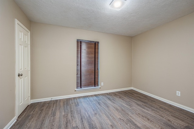 empty room featuring wood-type flooring and a textured ceiling