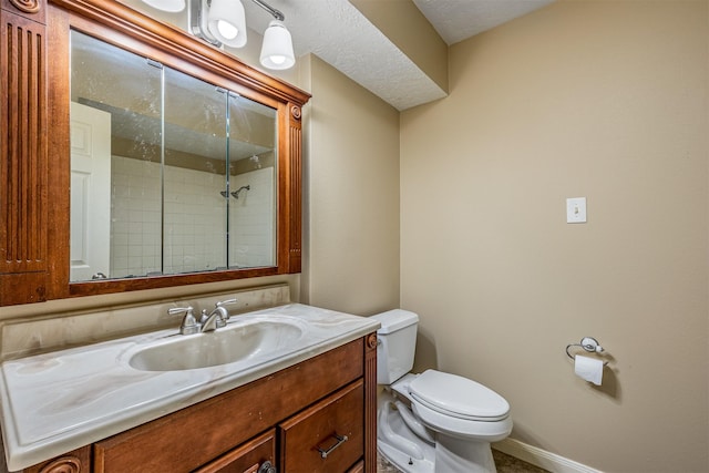 bathroom featuring vanity, toilet, and a tile shower