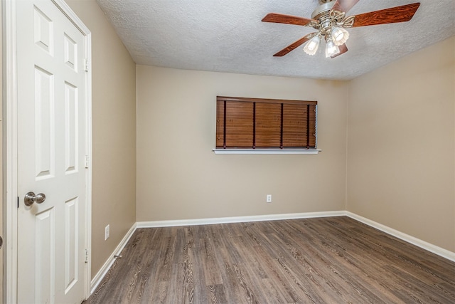 empty room with ceiling fan, dark wood-type flooring, and a textured ceiling