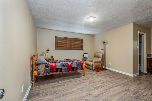 bedroom featuring wood-type flooring and a textured ceiling