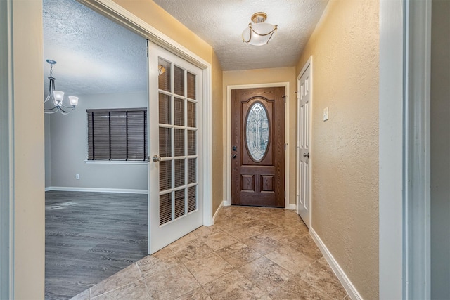 doorway to outside featuring a chandelier and a textured ceiling