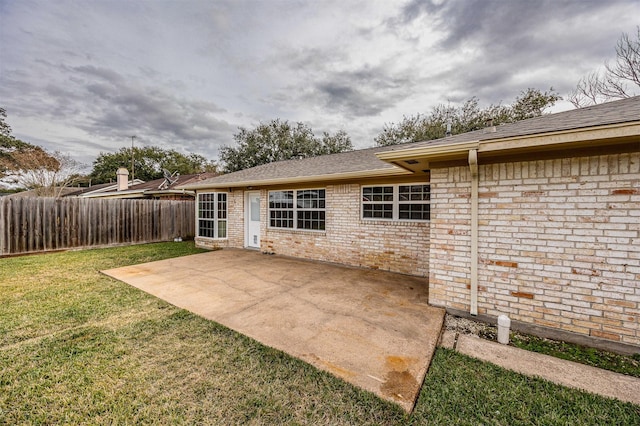 back of house featuring a patio area and a lawn