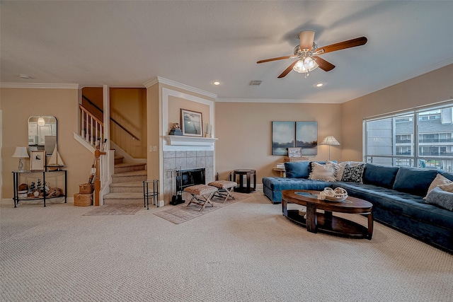 carpeted living room featuring a fireplace, ornamental molding, and ceiling fan