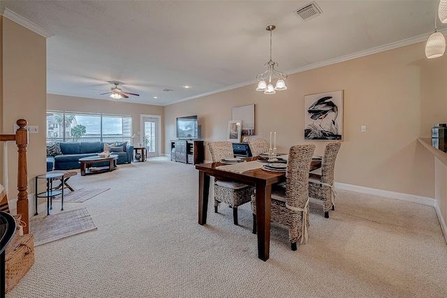 carpeted dining space with ceiling fan with notable chandelier and ornamental molding