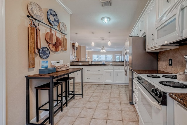 kitchen featuring pendant lighting, white appliances, a breakfast bar, white cabinetry, and tasteful backsplash