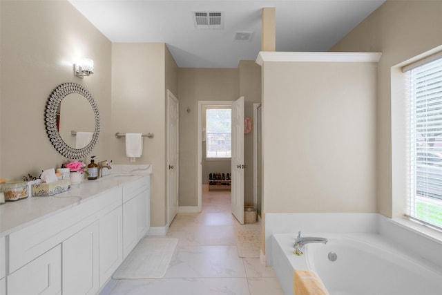 bathroom with vanity, plenty of natural light, and a tub to relax in