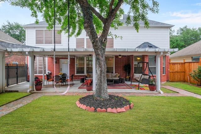 back of property with a patio, outdoor lounge area, a yard, and ceiling fan