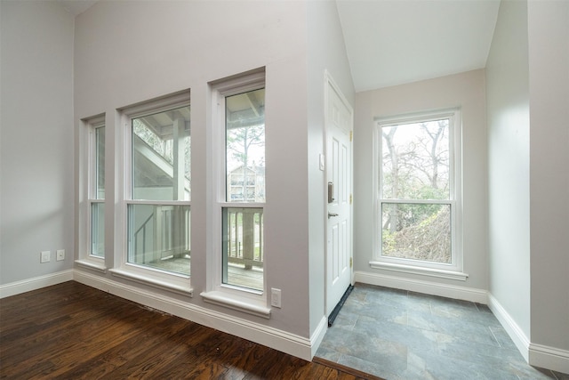 entryway with lofted ceiling and dark hardwood / wood-style flooring