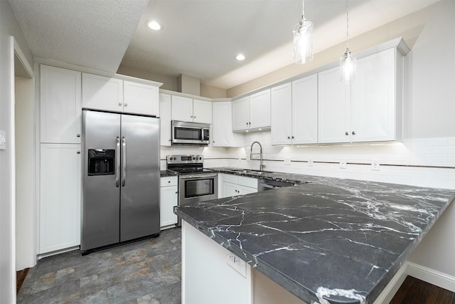 kitchen with stainless steel appliances, white cabinetry, sink, and decorative light fixtures