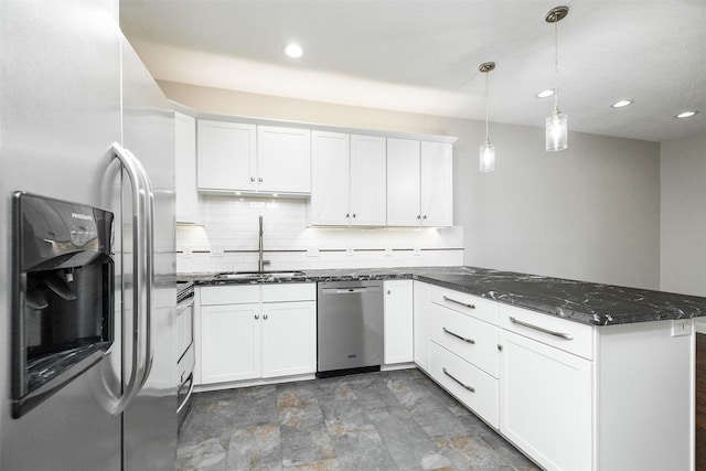 kitchen with stainless steel appliances, kitchen peninsula, hanging light fixtures, and white cabinets