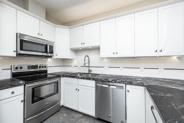 kitchen featuring white cabinetry, sink, dark stone countertops, and appliances with stainless steel finishes